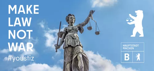 Kammergericht Berlin Schriftzug Make Law Not War auf blauem Himmel, daneben eine Justicia