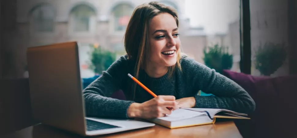 Laptop mit Studentin, die lacht