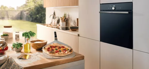 Gorenje PizzaPlus Einbaubackofen Gorenje PizzaPlus Einbaubackofen in der Küche, davor eine frische Pizza