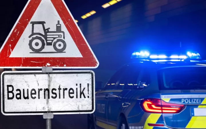 Achtungsschild mit Bauernstreik-Aufschrift und Polizeiauto