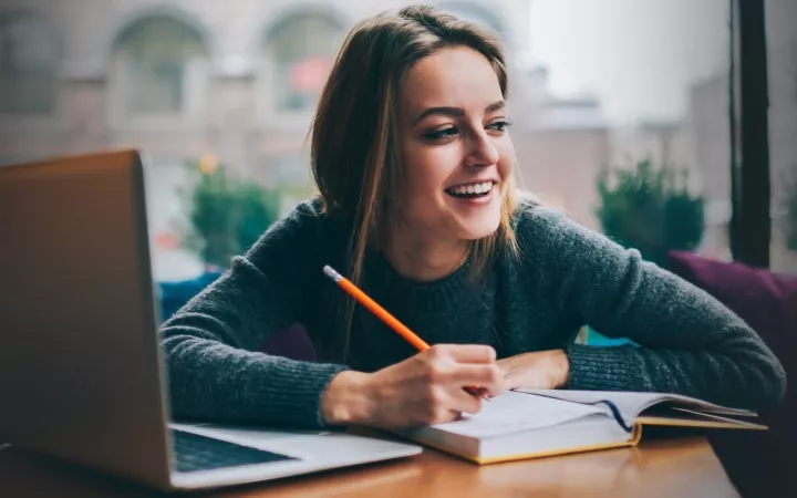 Laptop mit Studentin, die lacht