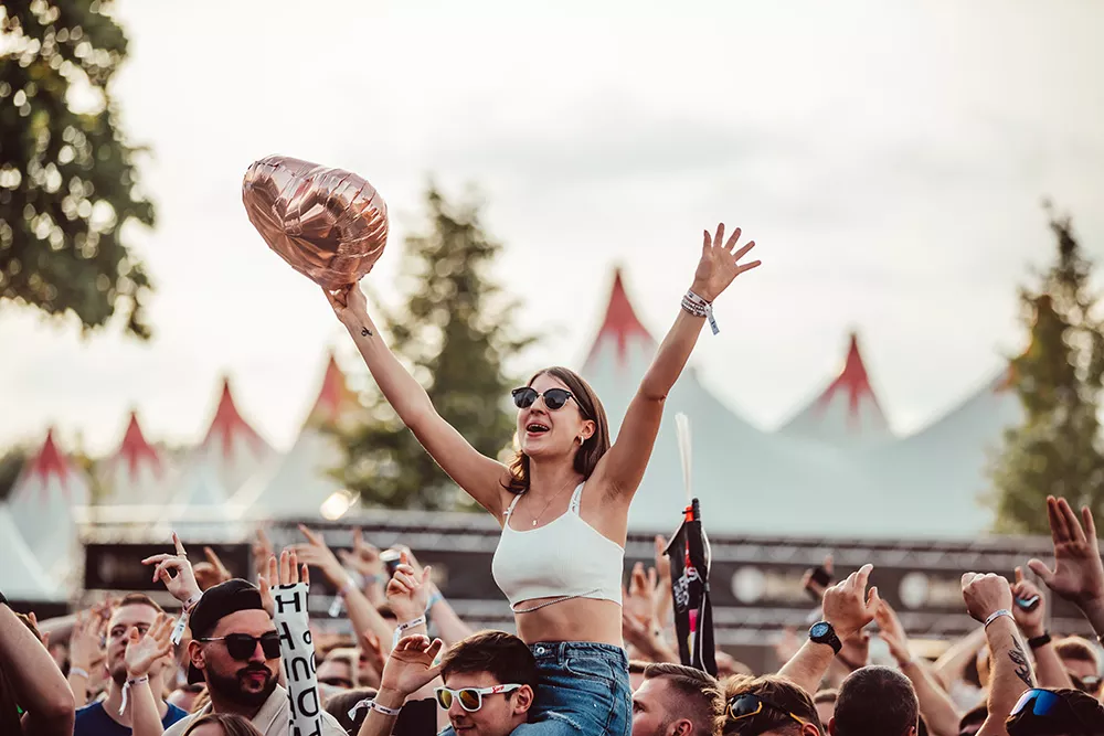 Junge Frau auf dem Tante Mia Tanzt Festival auf den Schultern einer anderen Person